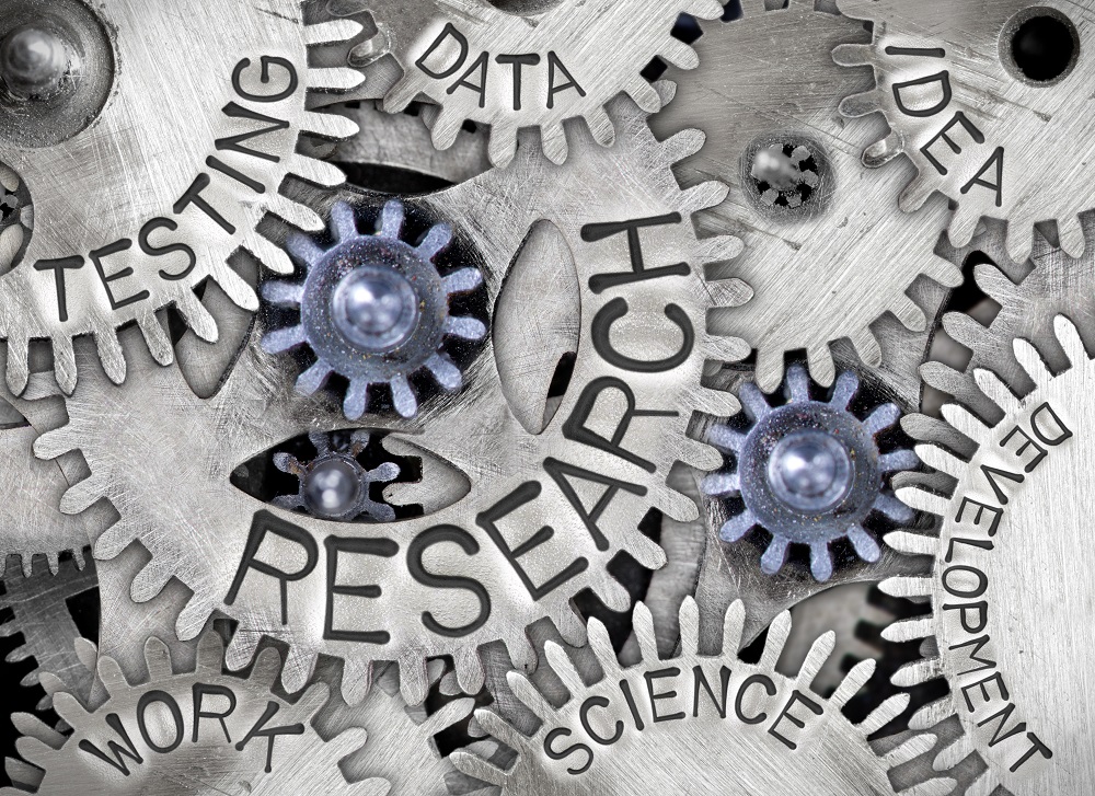 Macro photo of tooth wheel mechanism with RESEARCH concept related words imprinted on metal surface